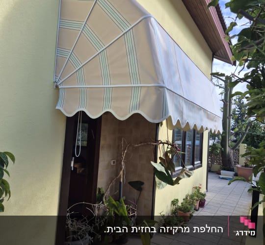 סוכך מותקן מעל דלת כניסה עם צמחים מסביב